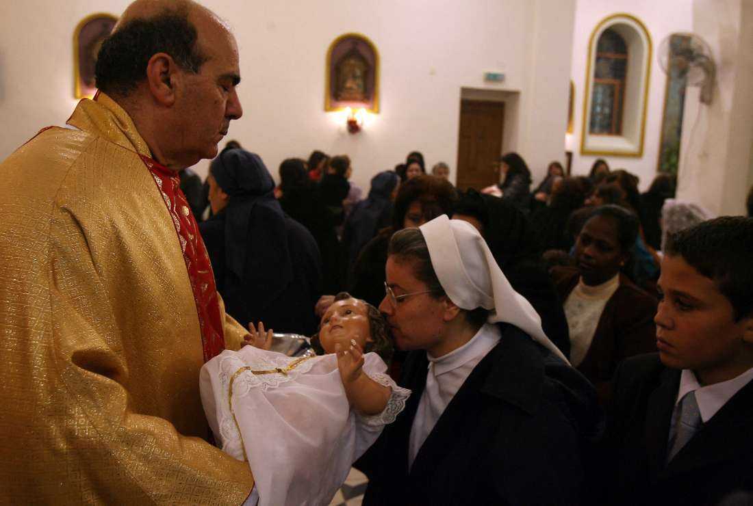 A Jordanian Latin Priest (left) holds a religious service during a Christmas celebration in al-Fuheis city, outside of Amman, Dec. 24, 2007