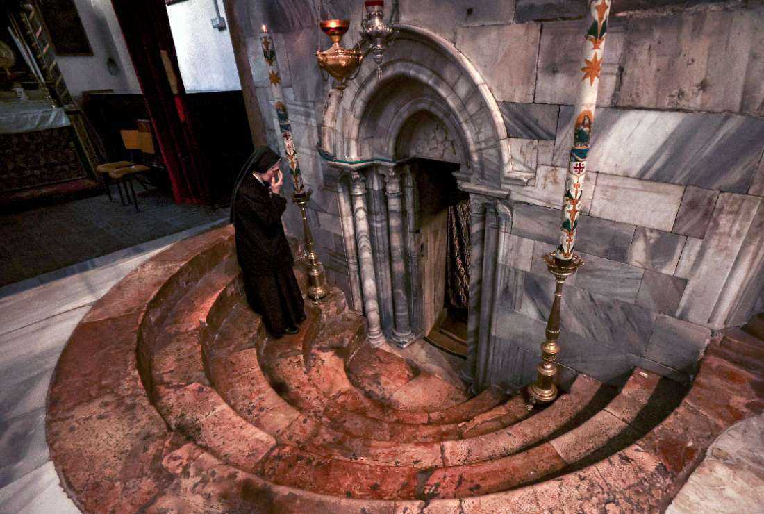 A nun crosses herself as she descends to enter the crypt of the grotto, believed to be the site of the birth of Jesus, at the Church of the Nativity in the biblical city of Bethlehem in the occupied West Bank on Christmas Day on Dec. 25, 2022. 