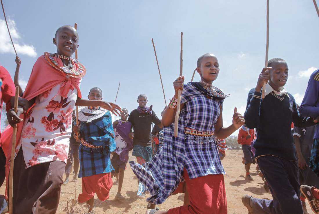 Youth from the Maasai community run to welcome US First Lady Jill Biden (not seen) during her visit to Loseti in Kajiado county, Kenya, on Feb. 26 where she heard about the impoverishing impact of drought on the herder community during her visit to Kenya.
