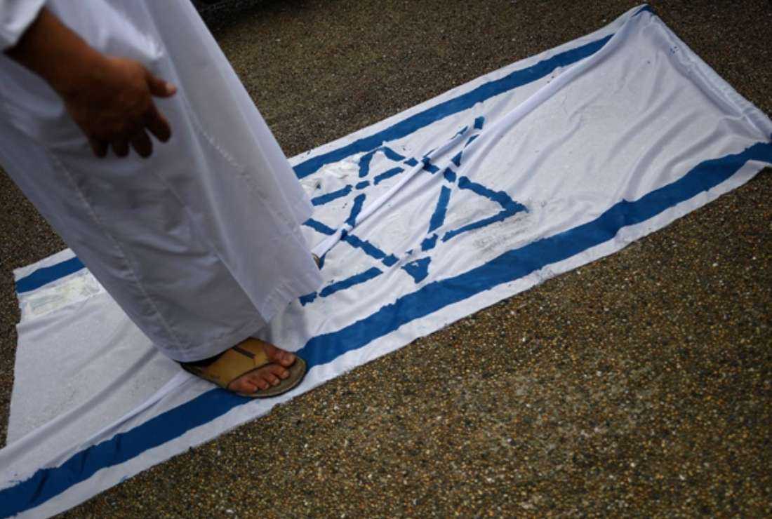  A Malaysian Muslim man steps on the Israeli flag during a solidarity protest after Friday prayers outside the National Mosque in Kuala Lumpur on July 28, 2017. Since the events of Oct. 7 in Israel and the Gaza Strip, boycott lists are being shared by Muslim-Malays to rally support for Palestine on social media.