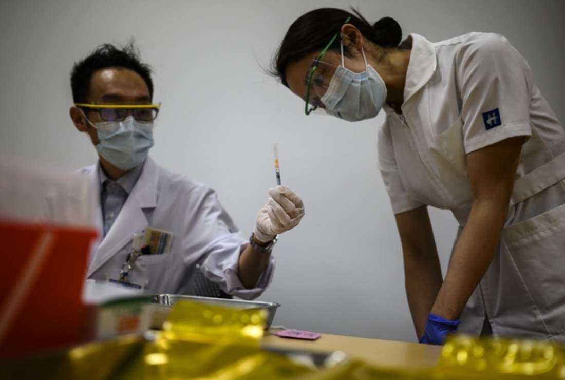 A Japanese nurse inspects a syringe after it is filled by a medical worker with a dose of Covid-19 vaccine as Japan launched its inoculation campaign in Tokyo prefecture in February 2021