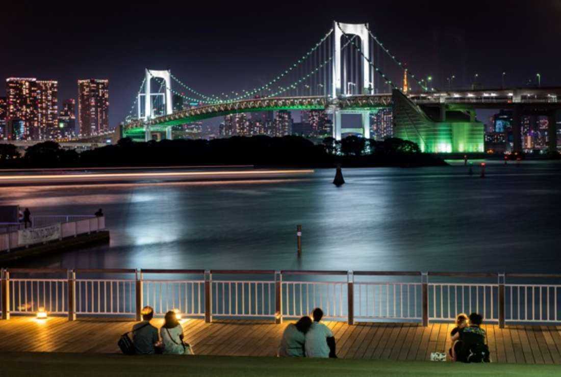  Couples in Japan enjoying the night view of Rainbow Bridge along Tokyo Bay.