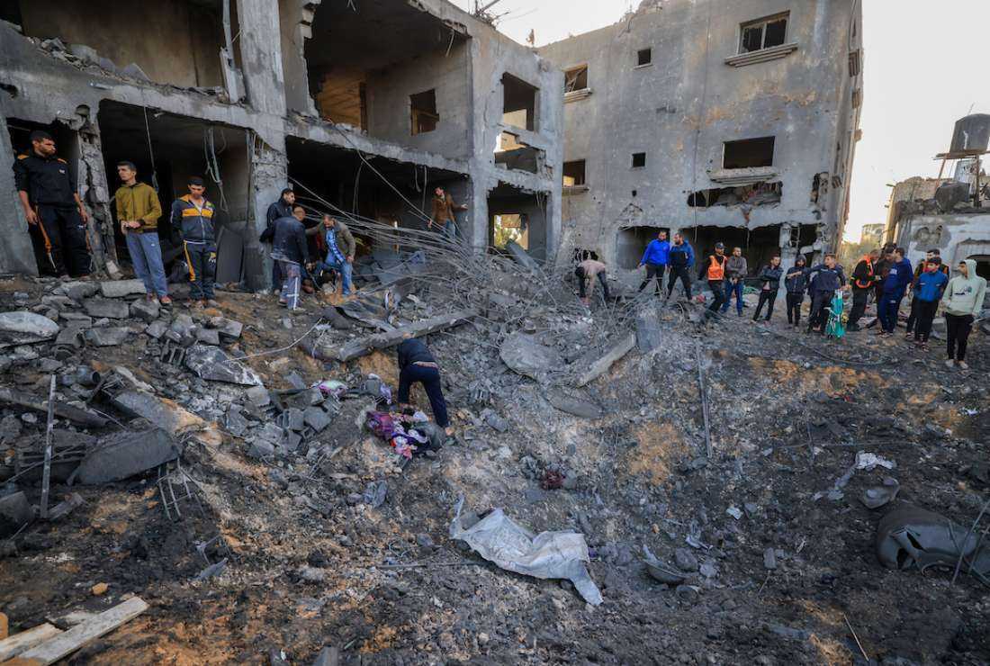Rescuers look for survivors in the rubble of the al-Agha family home following an Israeli strike in Khan Yunis on the southern Gaza Strip on Nov. 23 amid continuing battles between Israel and the Palestinian militant group Hamas.