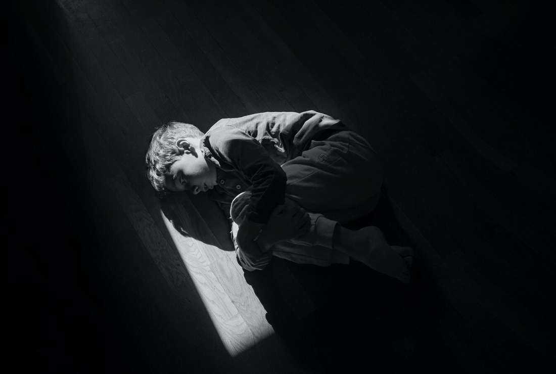 A staged image shows a child lying on the floor.