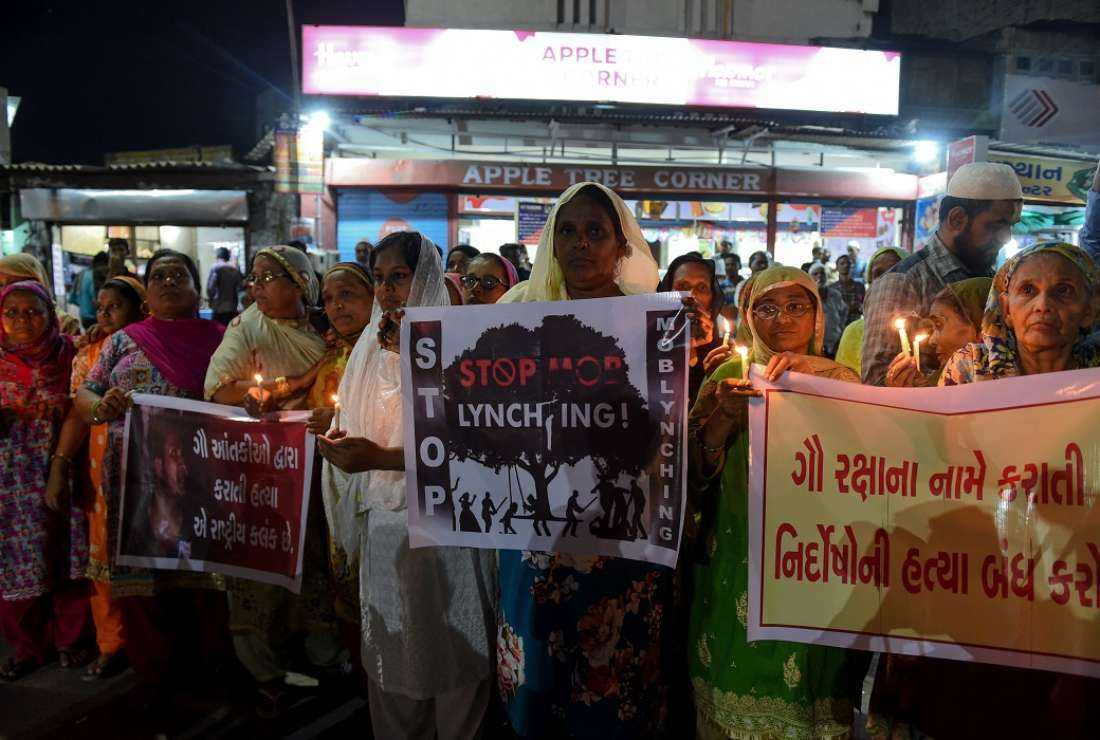 In this file photo, Indian women hold candles and posters as they protest against the mob lynching of a Muslim man in Jharkhand state, in Ahmedabad on June 27, 2019. A Catholic man was beaten to death as part of a lynching in the same state on Dec. 14