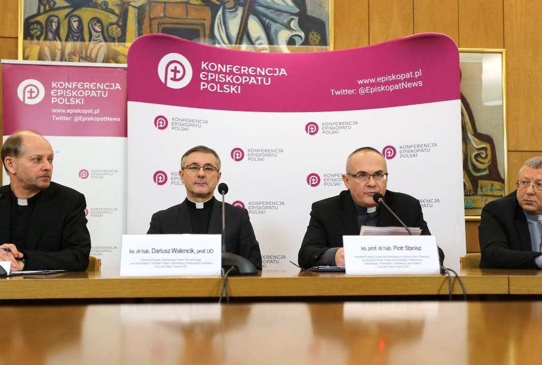 Father Leszek Gesiak, spokesman of the Polish bishops' conference, (left) is seen at a Jan. 9 press conference in Warsaw with university professors explaining church financing and taxation of clergy