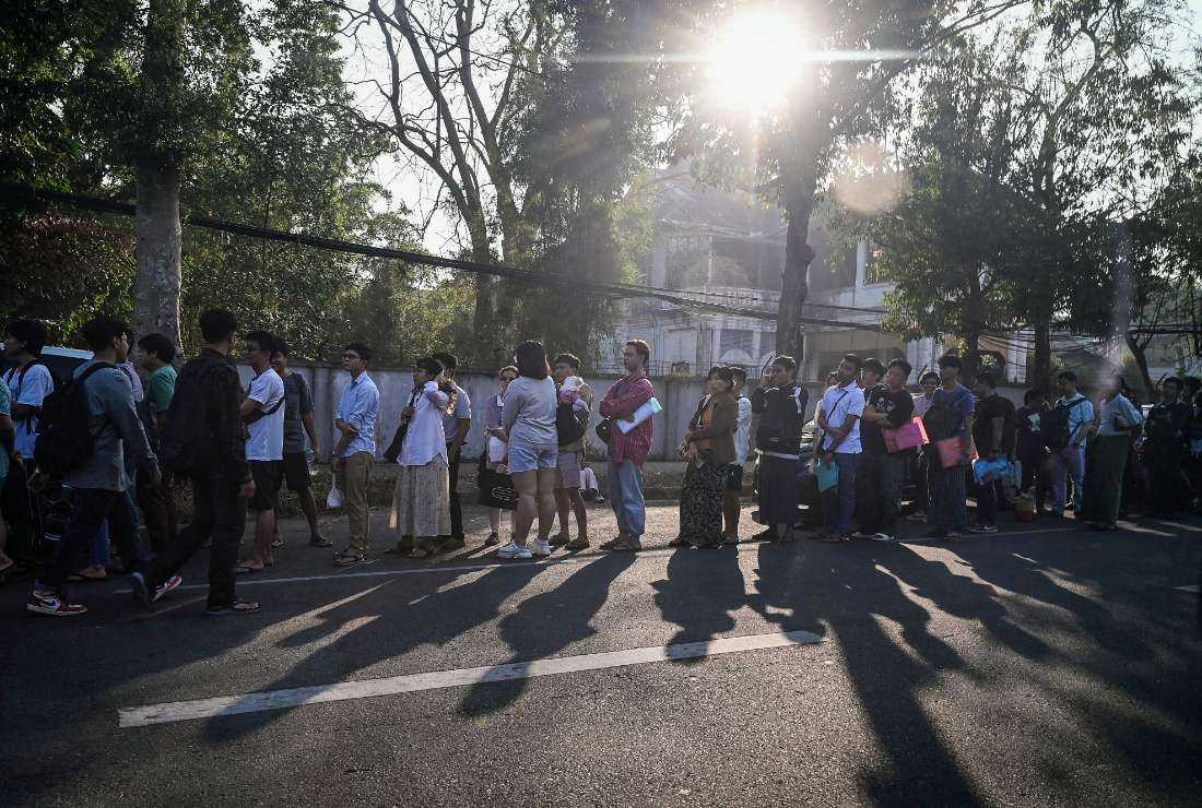 People stand in line to get visas at the embassy of Thailand in Yangon on Feb. 16 after Myanmar's military government said it would impose military service. 