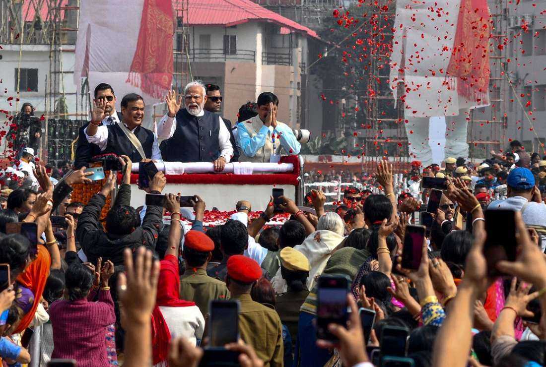 India's Prime Minister Narendra Modi (center) along with Chief Minister of Assam Himanta Biswa Sarma (center left) waves to Bharatiya Janata Party supporters during a public rally in Guwahati, Assam on Feb 4, 2024.