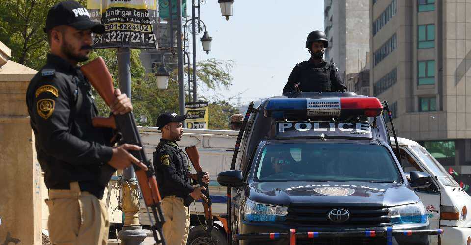Police stand guard outside a polling station during Pakistan's national elections in Karachi on Feb. 8.