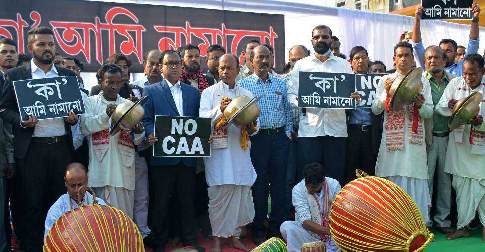 Activists of All Assam Students’ Union (AASU) hold placards and play traditional instruments during a protest against the Indian government's Citizenship Amendment Act (CAA) in Guwahati on Dec. 12, 2020.