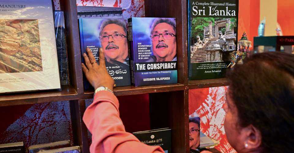 A woman looks at the copies of the 'The Conspiracy' book written by toppled Sri Lankan president Gotabaya Rajapaksa displayed at a bookshop in Colombo on March 7. 