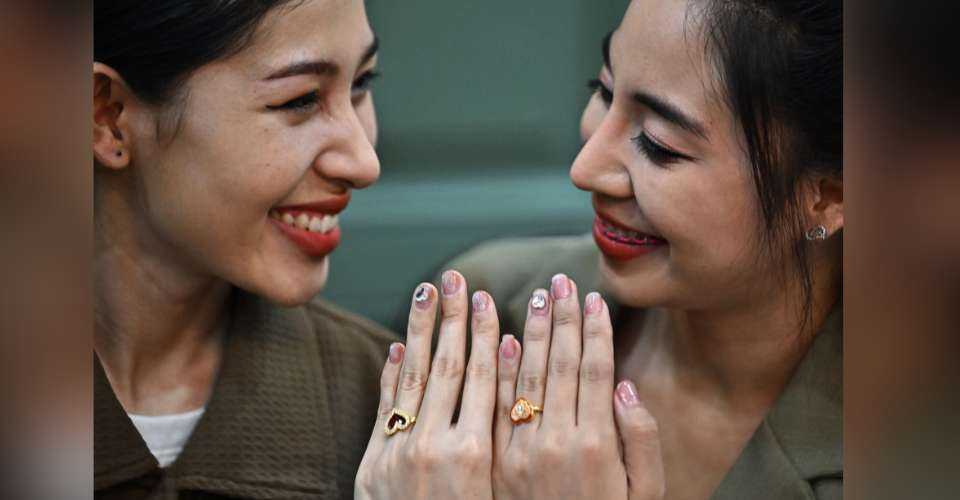 An LGBTQIA+ couple shows off their rings for photographers during a symbolic marriage registration event despite Thailand not recognizing same-sex marriages in Dusit district in Bangkok on Feb. 14, 2023