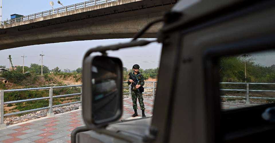 Thai military personnel keep guard along the Moei river on the Thai side, next to the 2nd Thai-Myanmar Friendship Bridge, in Thailand's Mae Sot district on April 12. Myanmar troops have withdrawn from their positions in a trade hub near the Thai border, a spokesman for the junta said, confirming reports from an ethnic armed group that has been battling the military for days.