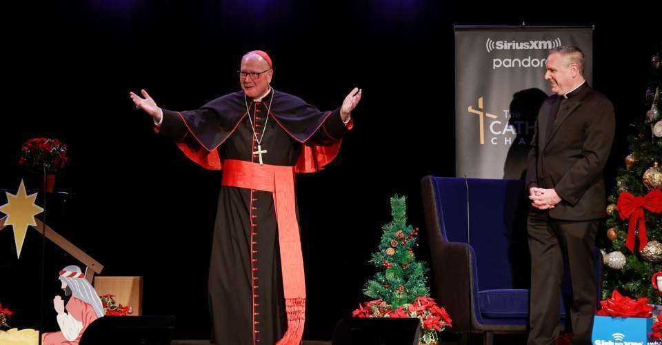 Cardinal Timothy M. Dolan and Father Dave Dwyer speak during Cardinal Dolan's annual SiriusXM Christmas special on The Catholic Channel at The Sheen Center on December 08, 2022, in New York City