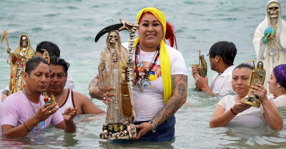 Devotees enter the sea with images of Santa Muerte during a gratitude ceremony for favors received at the beach of Puerto Juarez in Cancun, Quintana Roo State, Mexico, on Nov. 1, 2023.