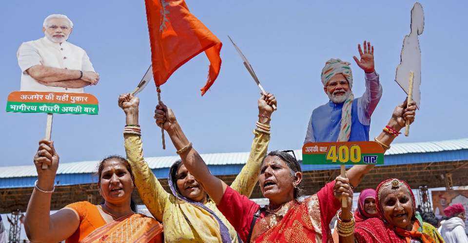 Women supporters carrying cutouts of Indian Prime Minister Narendra Modi attend an election campaign rally in Pushkar on April 6, ahead of the country's upcoming general election.