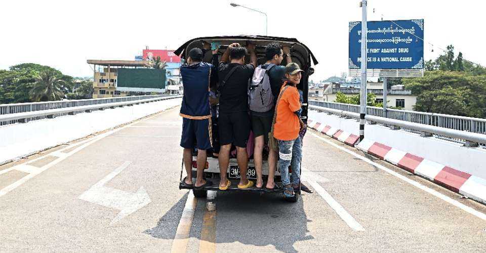 Returning Myanmar nationals ride a pick-up van back to Myanmar on the Thailand-Myanmar Friendship bridge after crossing the Tak immigration checkpoint in Thailand's Mae Sot district on April 12. 