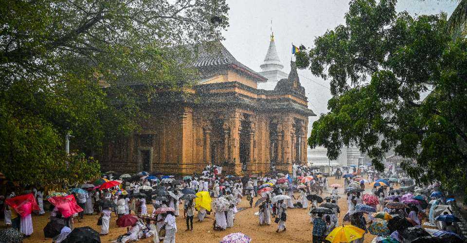 Buddhist devotees arrive to offer prayers amid rainfall at the Kelaniya Buddhist Temple during the Vesak festival to commemorate the birth, enlightenment and death of Buddha, in Kelaniya, Sri Lanka, on May 23. 