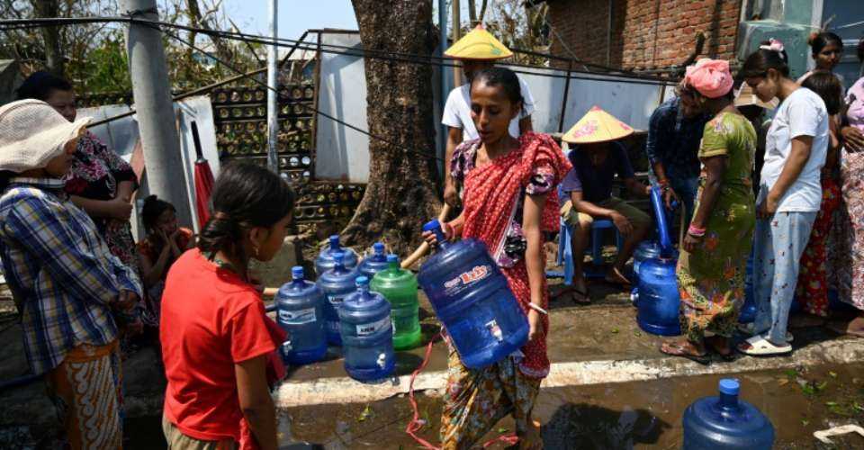 People in Sittwe, the capital of Rakhine state in western Myanmar, queue for water and rice on May 17, 2023, in the aftermath of Cyclone Mocha's landfall.