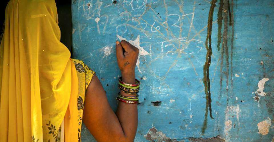 In this photograph taken on May 6, a woman from an Indian marginalized community stands outside a house in Ayela village on the outskirts of Agra.