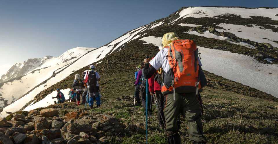 People are seen trekking on a mountain.