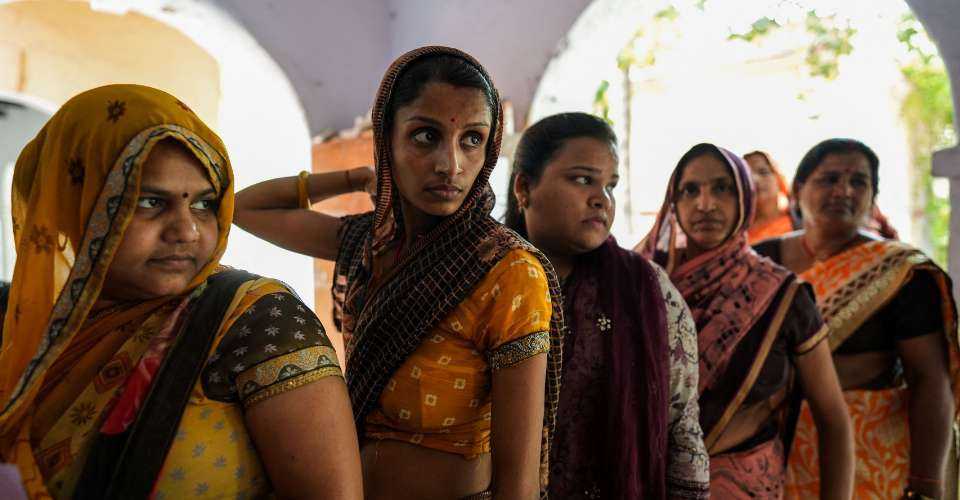 Women voters queue to cast their ballot at a polling station during the third phase of India's general elections, in Ganeshpura, Morena district, Madhya Pradesh on May 7