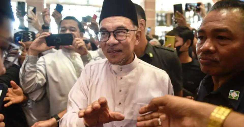Malaysia's Prime Minister Anwar Ibrahim greets people as he leaves Putra Mosque after prayers in Putrajaya in this file photo. 