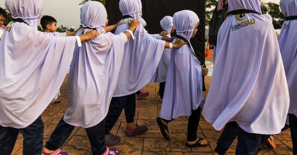 Hijab-clad Muslim girls take part in a religious ritual in Kuala Lumpur. Under Malaysian federal law, a minor cannot be converted to another faith without explicit parental permission.