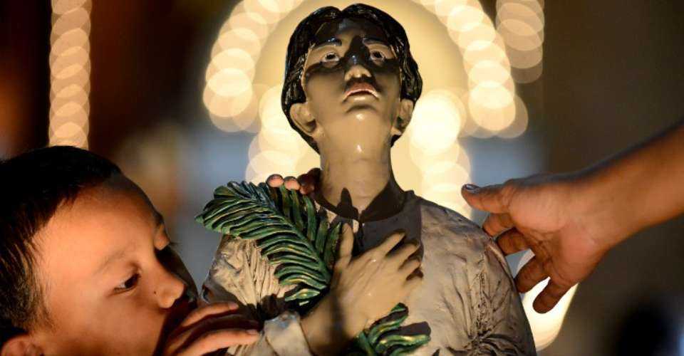 A boy kisses the statue of Pedro Calungsod at Saint Gregory the Great parish in Cebu, Philippines on Oct. 20, 2012, just before he was made a saint by Pope Benedict XVI.