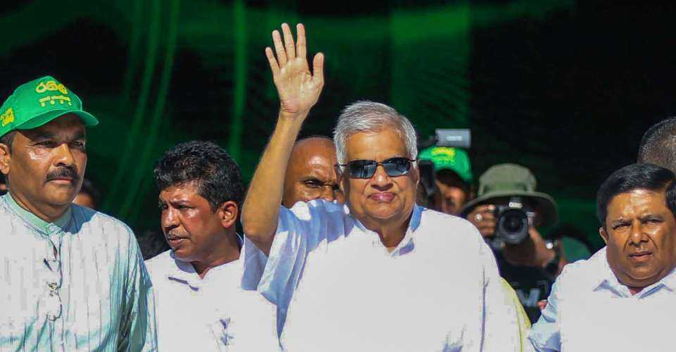 Sri Lankan President Ranil Wickremesinghe (center) waves as he takes part in a rally to mark International Labour Day in Colombo on May 1.