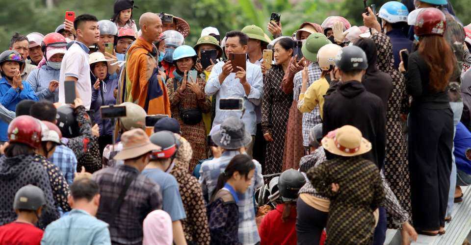 Thich Minh Tue (center) standing among residents in Ha Tinh province on May 17.