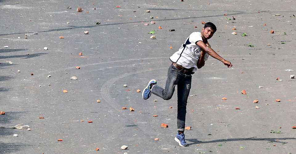 A protester pelts stones as students clash with police during the ongoing anti-quota protest in Dhaka on July 18. 