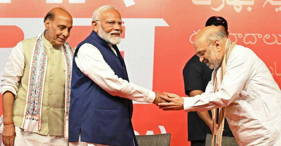 Bharatiya Janata Party leader Amit Shah (right) shakes hands with India’s Prime Minister Narendra Modi (center) as India’s Defence Minister Rajnath Singh looks on during the celebrations after their victory in India's general election, in New Delhi on June 4.