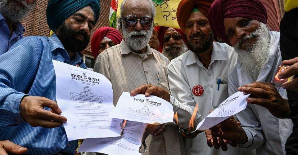 Members of rights organizations burn copies of three new criminal laws that took effect in India replacing British-era codes, in Amritsar on July 1.