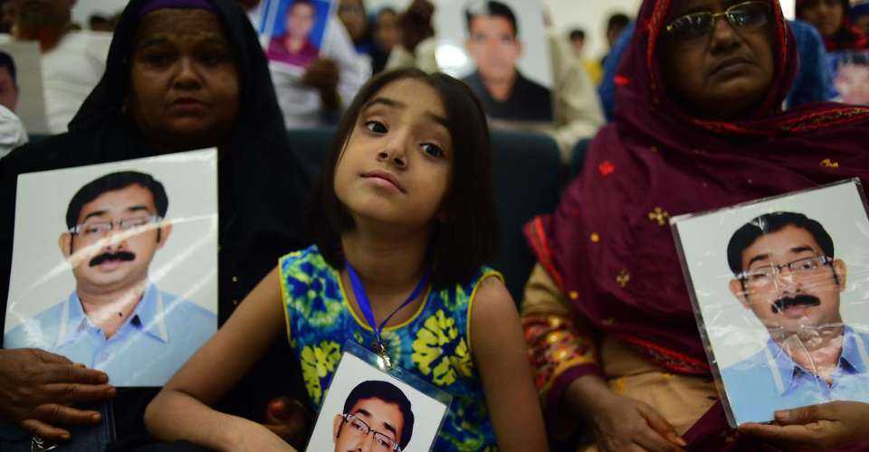 Relatives hold photos of a disappeared person during a press meeting in Dhaka on August 30, 2018. Rights groups say about 709 people became victims of disappearance during the Awami League regime since 2009.