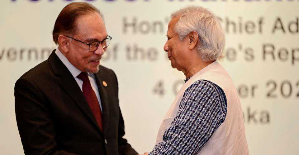 Anwar Ibrahim (left), prime minister of Malaysia, shakes hands with Muhammad Yunus, chief adviser of Bangladesh's interim government, during a joint press conference in Dhaka on Oct. 4.