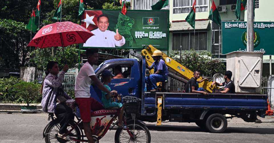 People drive past an election campaign billboard of Myanmar's chairman of the army-backed ruling Union Solidarity and Development Party (USDP), Khin Yi, ahead of the start of the election campaign in Yangon on Oct. 27.